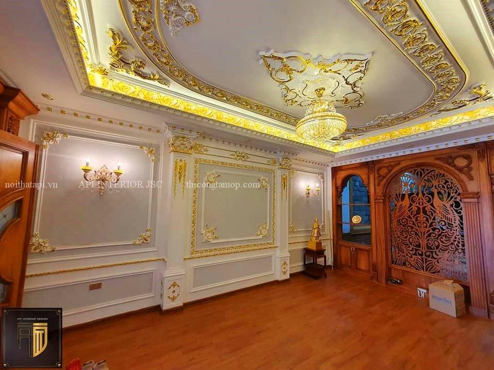 Không gian phòng khách màu vàng kết hợp với tấm ốp sàn SPC màu nâu đỏ giúp nổi bật không gian phòng hơn
